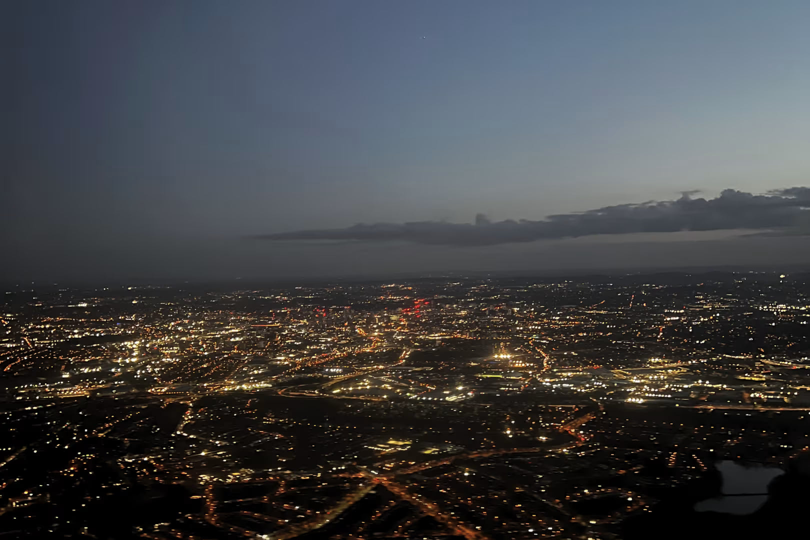 UK cityscape at night with illuminated buildings and roads.